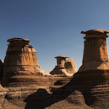 A hoodoo is a tall, thin spire of rock that protrudes from the bottom of an arid drainage basin or badland.