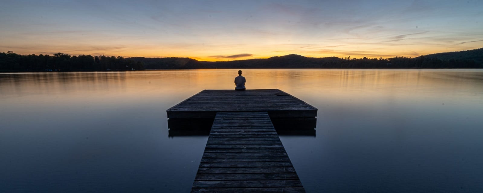a man sit near the lake