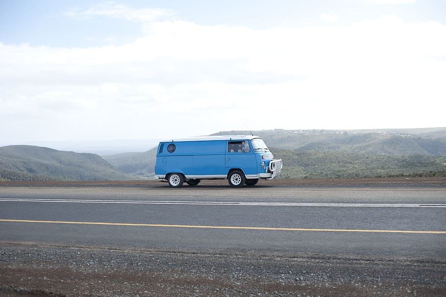 blue van driving on highway