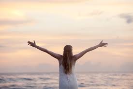 happy woman with outstretched arms at beach